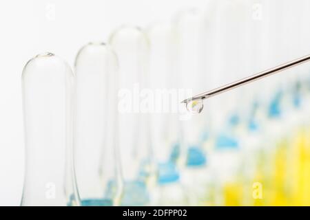 Verschwommene Glasampullen mit hypodermischer Spritze für Covid-Impfstoff, UK-Cunding Covid, V Day, Coronavirus-Impfstoff & scharfe Spritzenspitze auf neutralem B/Boden Stockfoto