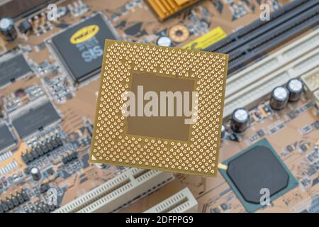 Gold Pinouts auf der Unterseite einer Desktop AMD CPU mit Mainboard. Dies ist eine ältere Sempron SDA2200DUT3D, die eine OEM-Version von AMD-Chip war. Stockfoto