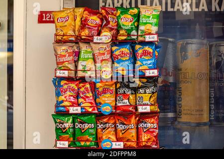 Verpackte FMCG-Produkte (Fast Moving Consumer Goods), darunter Kartoffelchips und Maischips, die in einem Straßenregal eines Kiosks ausgestellt sind. Stockfoto