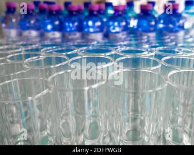 Selektiver Fokus auf leere saubere transparente Gläser. Es gibt eine Menge Flaschen mit Getränken auf einem unscharfen Hintergrund. Catering. Bankett. Stockfoto