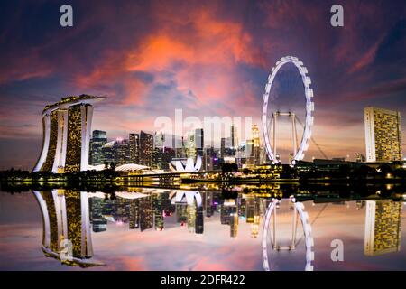 Atemberaubender Blick auf die Skyline von Singapur bei einem wunderschönen und dramatischen Sonnenuntergang. Singapur ist ein souveräner Inselstadtstaat in Südostasien. Stockfoto