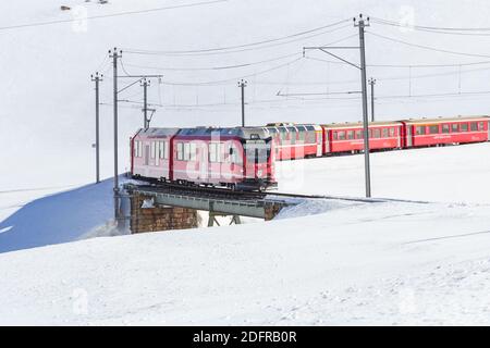 BERNINA, Schweiz - Jan 2020: BERNINA Express, roter Zug in der Wintersaison. Stockfoto