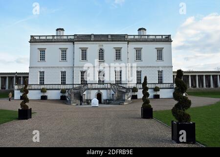 Das Queens House, eine ehemalige königliche Residenz in Greenwich Park, London. Zwei Treppen führen den Weg zu einer erhöhten Terrasse. Ein Besucher steht draußen. Stockfoto