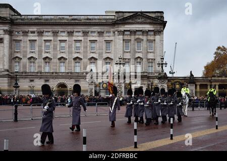 Die Wachablösung am Buckingham Palace, London. Graue Soldaten marschieren an Menschenmassen entlang der Mall vorbei, gefolgt von zwei Polizisten, die Pferde reiten. Stockfoto