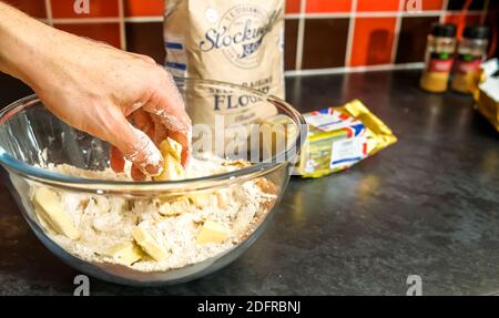 Norwich, Norfolk, Großbritannien – Dezember 06 2020. Illustrative redaktionelle Fotografie eines nicht identifizierbaren Hausbäckers reiben etwas Butter in Mehl, Ingwer und Stockfoto