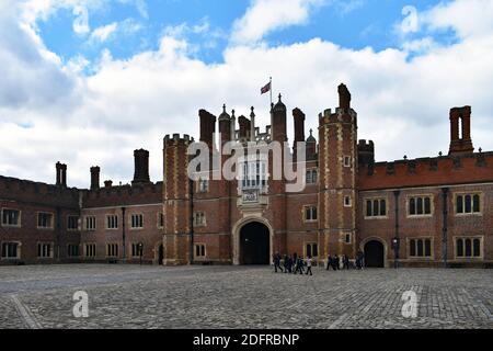 Eine Schulgruppe von Kindern geht um den Base Court im Hampton Court Palace in Richmond, London. Tudor-Architektur aus rotem Backstein. Stockfoto