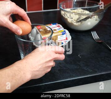 Norwich, Norfolk, Großbritannien – Dezember 06 2020. Illustrative redaktionelle Fotografie von nicht identifizierbaren Hausbäcker Knacken ein Tesco Branded freien Bereich Ei Stockfoto