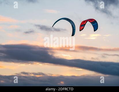 Zwei Drachen fliegen hoch oben über Wolken am Himmel bei Sonnenuntergang, Schottland, Großbritannien Stockfoto