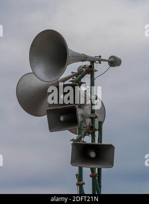 Tannoy oder Lautsprechersystem gegen einen dunklen, absenkenden Himmel - monochrom. Dystopische Vorschläge. Stockfoto