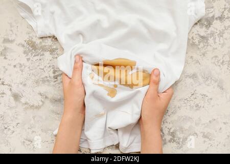 Frau mit verschüttete Tasse Kaffee auf T-Shirt, Nahaufnahme Stockfoto