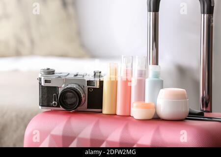 Fotokamera und Reisetaschen mit Körperpflege Kosmetik auf verpackten Koffern Stockfoto