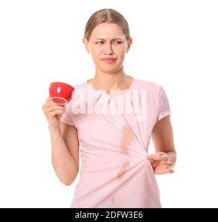 Gestresste junge Frau mit Kaffeeflecken auf ihrem Hemd Weißer Hintergrund Stockfoto
