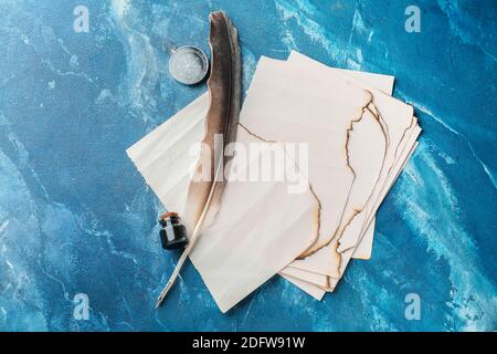 Federstift, Tinte, Papierblätter und Kompass auf dem Tisch Stockfoto