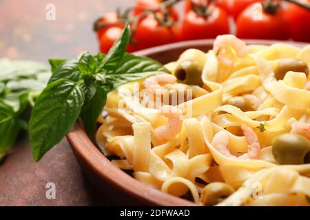 Teller mit leckeren Nudeln mit Garnelen und Kirschtomaten auf Tabelle Stockfoto