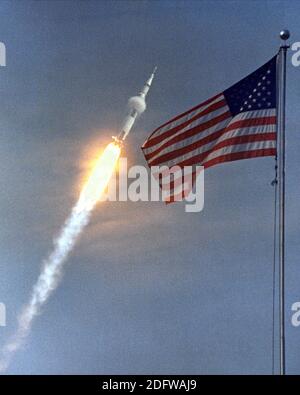 Cape Canaveral, FL - (Datei-) - die amerikanische Flagge läutet der Flug von Apollo 11, die erste Mondlandung Mission. Das Raumfahrzeug Apollo 11 Saturn V abgehoben mit Astronauten Michael Collins, Neil A. Armstrong und Edwin E. Aldrin, Jr., um 9:32 Uhr EDT 16. Juli 1969, vom Kennedy Space Center Launch Complex 39A. Während der geplanten acht-Tage-Mission wird Armstrong und Aldrin absteigen in einer Mondlandefähre auf der Oberfläche des Mondes während Collins Mehraufwand bei der Monitorbox umkreist. Die beiden Astronauten sollen auf dem Mond, einschließlich zwei und eine halbe Stunden außerhalb der Mondfähre 22 Stunden verbringen. Th Stockfoto