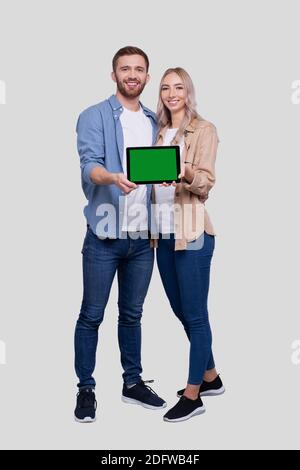 Paar Zeigt Tablet Green Screen Isoliert Stehend. Konzept Für Werbung, Werbung Und Werbung Stockfoto