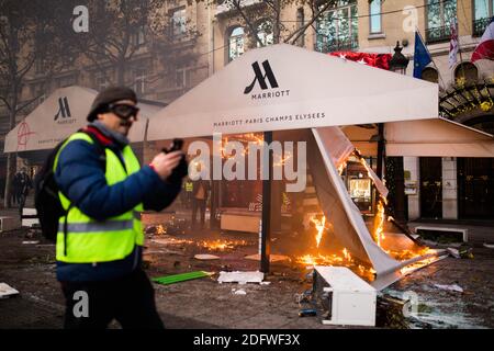 Marriott Paris. Gelbe Weste (Gilets jaunes) Protestierende laufen am 24. November 2018 bei einer Kundgebung gegen steigende Ölpreise und Lebenshaltungskosten am Triumphbogen auf den Champs Elysees in Paris vorbei an brennendem Material. Sicherheitskräfte in Paris feuerten am 24. November Tränengas und Wasserwerfer ab, um Demonstranten zu zerstreuen. Mehrere tausend Demonstranten, die in gut sichtbaren gelben Jacken unterwegs waren, hatten sich im Rahmen der Proteste, die am 17. November 2018 begannen, auf der Straße versammelt. Foto von Raphaël Lafargue/ABACAPRESS.COM Stockfoto