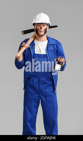 Bergmann mit Pick-Axt auf grauem Hintergrund Stockfoto