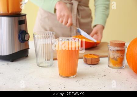 Frau bereitet leckere Kürbis Smoothie am Tisch Stockfoto