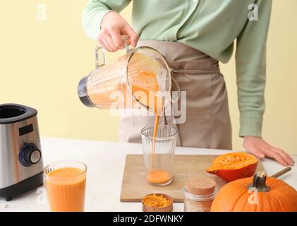 Frau bereitet leckere Kürbis Smoothie am Tisch Stockfoto