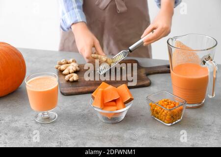 Frau bereitet leckere Kürbis Smoothie am Tisch Stockfoto