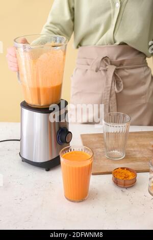 Frau bereitet leckere Kürbis Smoothie am Tisch Stockfoto