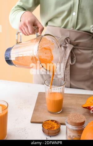 Frau bereitet leckere Kürbis Smoothie am Tisch Stockfoto