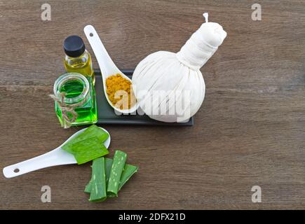 Spa Kräuter (Kurkuma Pulver in weißen Löffel, Aloe Vera ätherisches Öl und Gel ) auf Holzhintergrund Stockfoto