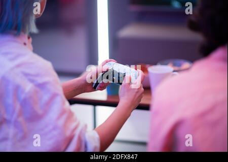 Mädchen mit dem neuen Sony PlayStation 5 DualSense Wireless-Controller, der immersive haptische Feedback, dynamische adaptive Trigger und eine integrierte bietet Stockfoto