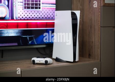 Die brandneue PlayStation 5-Spielekonsole von Sony mit DualSense-Controller in der Nähe des fernsehbildschirms zu Hause ist einsatzbereit. Moskau - November 28 2020. Stockfoto