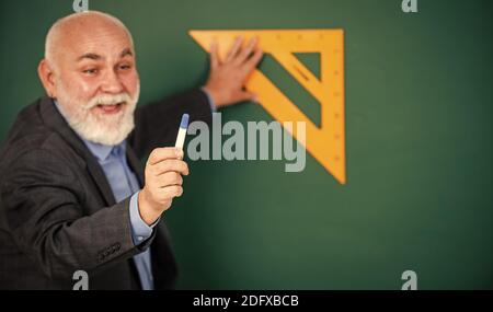 Logik, die beteiligt ist. Lieblingsthema. Senior Mann Lehrer verwenden mathematische Dreieck-Tool. Bärtige Tutor Mann an der Tafel. Zurück zur Schule. Mathematik und Menschen Konzept. Mathematik an Bord. Stockfoto