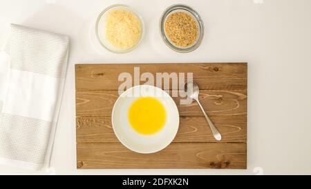 Geschmolzene Butter, Semmelbrösel und Parmesankäse aus nächster Nähe auf dem Küchentisch direkt von oben Stockfoto
