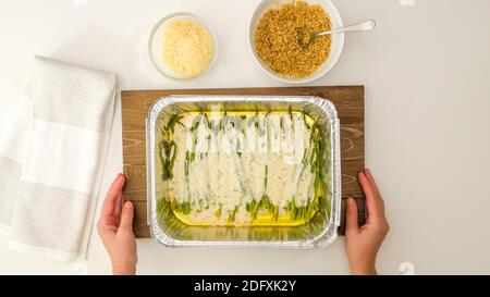 Spargelauflauf in einer cremigen Alfredo-Sauce Schritt für Schritt Rezept. Stockfoto