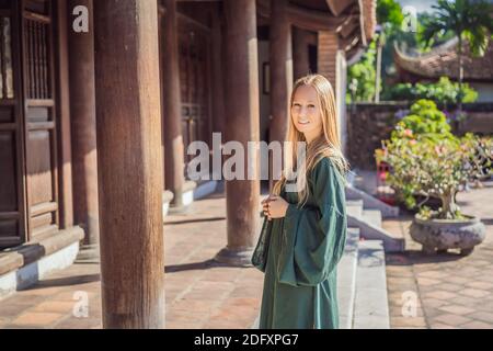 Frau Tourist in nationalen vietnamesischen Kleid im Tempel der Literatur in Hanoi in Südostasien, Vietnam. Vietnam wird nach der Quarantäne des Coronavirus wieder geöffnet Stockfoto