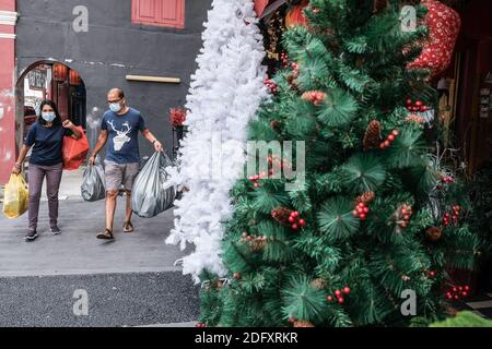 Kuala Lumpur, Malaysia. November 2020. Ein Paar trägt Gesichtsmasken gesehen Spaziergänge an Weihnachtsdekorationen in Kuala Lumpur.Trotz der Auswirkungen der Coronavirus Pandemie, die soziale Distanzierung erfordert, Kuala Lumpur Stadt immer noch durch die bunte Weihnachtsdekoration beleuchtet. Kredit: Faris Hadziq/SOPA Images/ZUMA Wire/Alamy Live Nachrichten Stockfoto