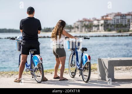 Straßenfotografie Miami Beach Paar auf Leihrädern Stockfoto