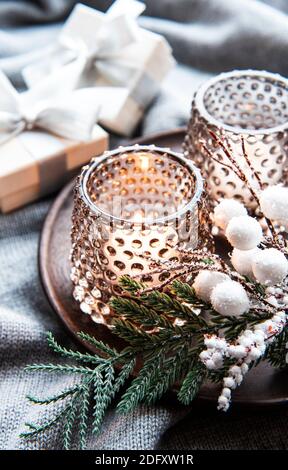 Weihnachten dekorative brennende Kerzen, Tannenzweig und Geschenk-Boxen über grauen Wollhintergrund. Stockfoto