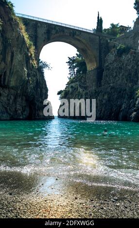 Fiordo di Furor, Amalfiküste, malerischer Meerblick vom Strand auf einer Bogenbrücke zwischen Felsen und türkisfarbenem Meer. Stockfoto