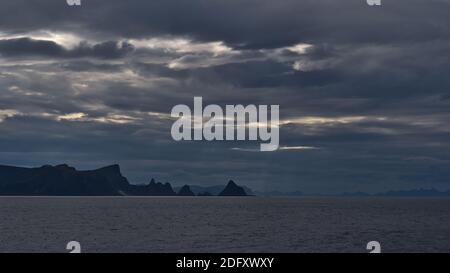 Schöne Aussicht auf die Nordküste der Insel Andøya in der Nähe von Fischerdorf Andenes, Vesterålen, Norwegen mit Bergen und dramatischen bewölkten Himmel. Stockfoto