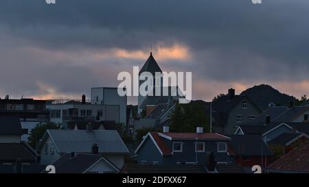 Schöne Aussicht über das Zentrum des Fischerdorfes Svolvær auf der Insel Austvågøya, Lofoten, Norwegen mit Kirche (Kirke), Häusern und Dächern im Abendlicht. Stockfoto