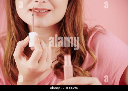 Frau, die flüssigen Lippenstift anwendet Stockfoto