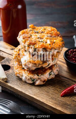 Gegrillter schneller asiatischer Fischkuchen aus Lachs und würzigen Kräutern, auf altem Holztisch Stockfoto