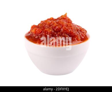 Adjika Sauce in Schüssel, isoliert auf weißem Hintergrund. Würzige Tomaten- und Chilischote-Sauce. Stockfoto