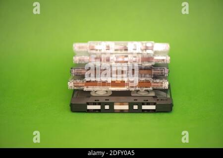 Ein Stapel Audioband-Kassetten aus Kunststoff auf grünem Hintergrund Stockfoto