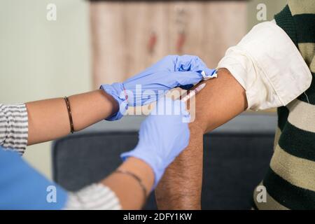 Nahaufnahme eines Arztes, der einen Impfschuss macht Die Schulter des Patienten zu Hause - Konzept von zu Hause Integritätsprüfung Stockfoto