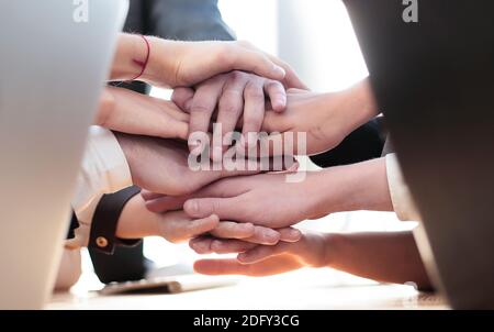 Nahaufnahme. Junge Mitarbeiter machen ihnen einen Turm aus der Hand Stockfoto