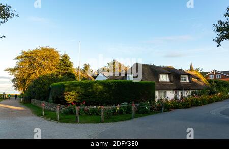 Amrum, Deutschland - 16. Oktober 2020: Traditionelles Strohhaus und Kirche am Morgen Stockfoto