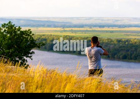 Rückansicht eines Fotografen, der Bilder von Flusslandschaft. Stockfoto