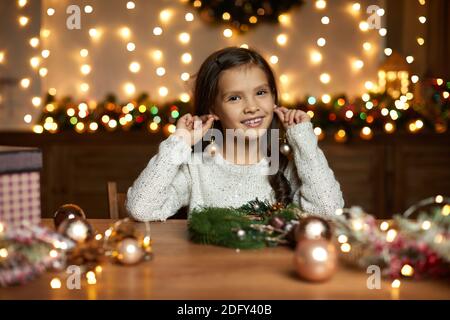 Glücklich lächelnd nettes kleines Kind Mädchen hält weihnachtsball zu Hause. Stockfoto