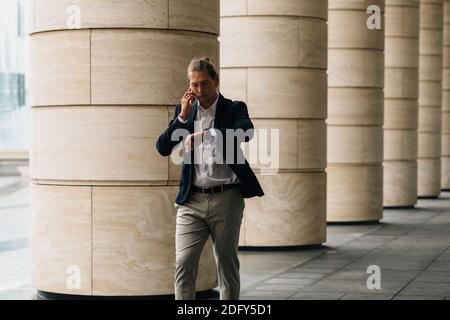 Junger Mann in formeller Kleidung im Gespräch auf Smartphone Stockfoto